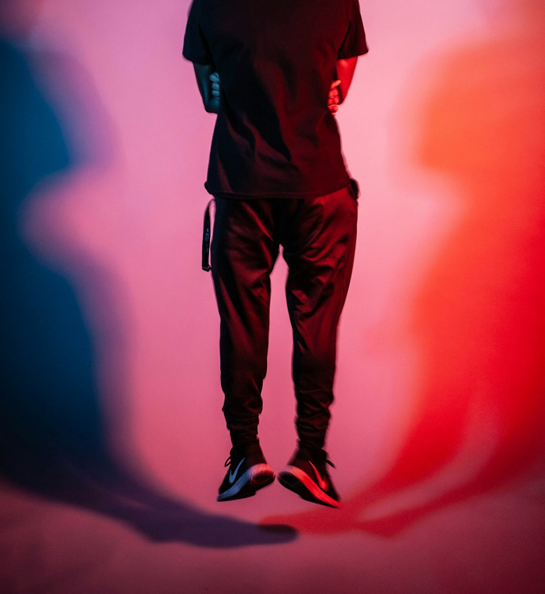 A man standing in the shadows of a red and blue background