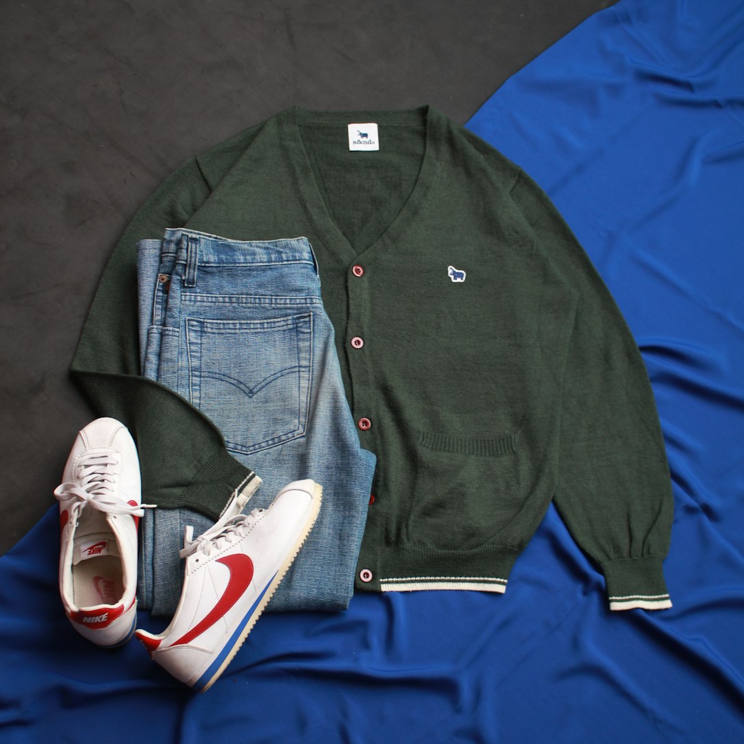 a pair of shoes, a sweater, and a pair of jeans lay on